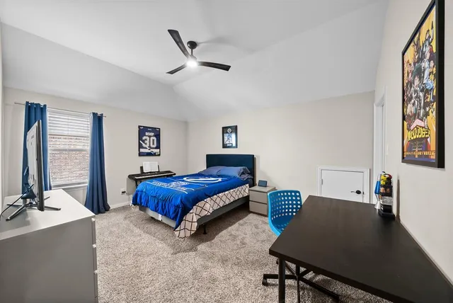 a bedroom with a bed window and a desk