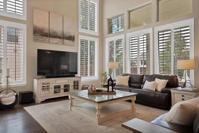 a living room with furniture a flat screen tv and a large window