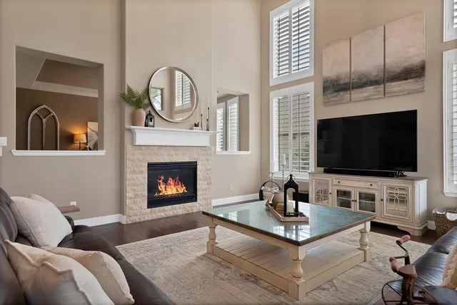 a living room with furniture a flat screen tv and a fireplace