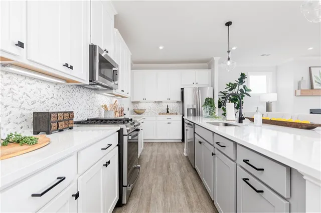 a kitchen with stainless steel appliances a table chairs refrigerator and microwave