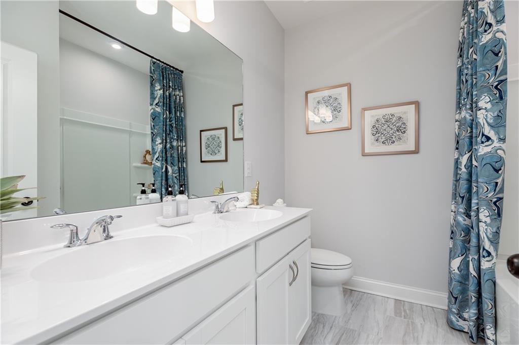 862 Leraes Way Loganville, GA 30052 - Photo 33 of 56 a bathroom with a granite countertop sink a toilet and a mirror
