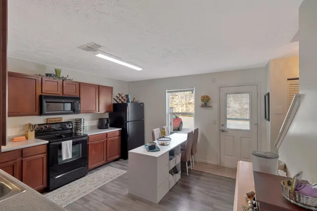 a kitchen with stainless steel appliances a stove top oven a sink dishwasher and a refrigerator