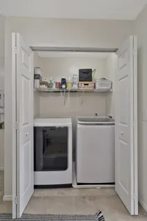 a utility room with stainless steel appliances washer and dryer