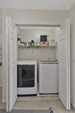 a utility room with stainless steel appliances washer and dryer