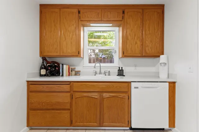a kitchen with white cabinets and a window