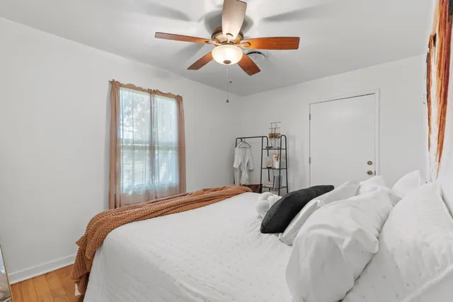 a bedroom with a large bed and a ceiling fan