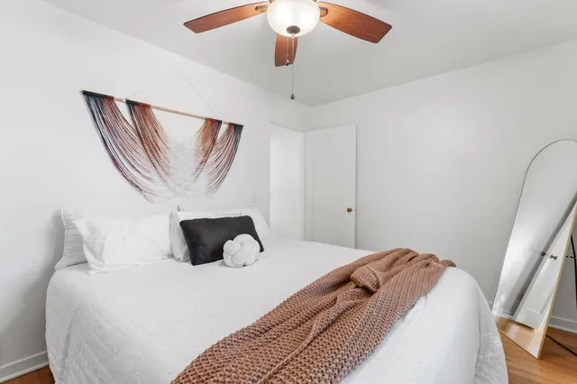 a bedroom with a large bed and a chandelier