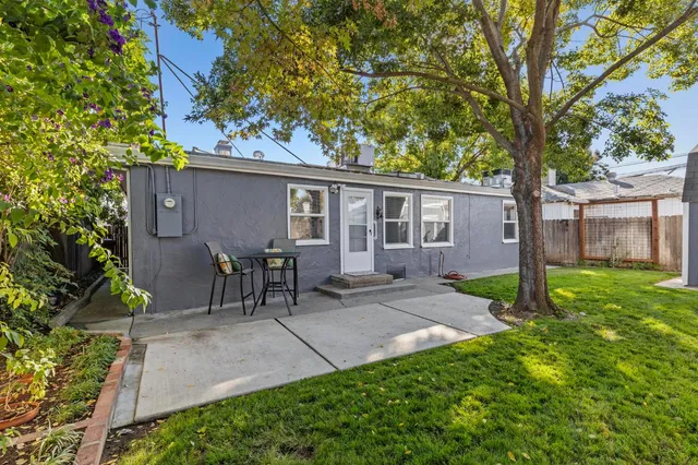 a view of a house with backyard and a tree