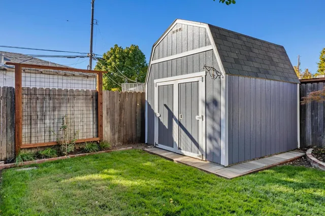 a view of a house with a yard and wooden fence