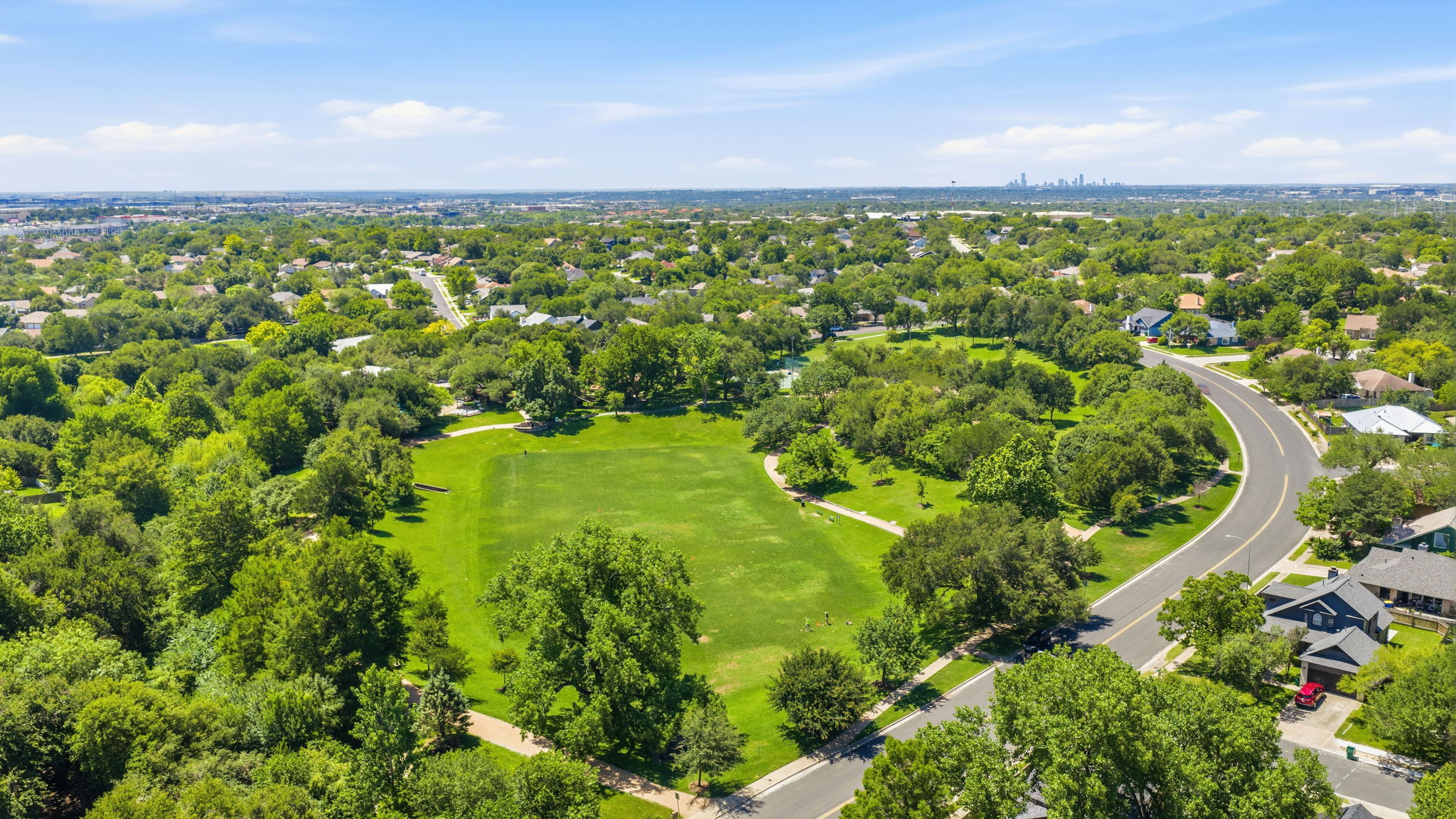 14818 Yellowleaf Trail Austin, TX 78728 - Photo 24 of 26 Expansive green space featuring a large manicured lawn bordered by mature trees and paved walking paths