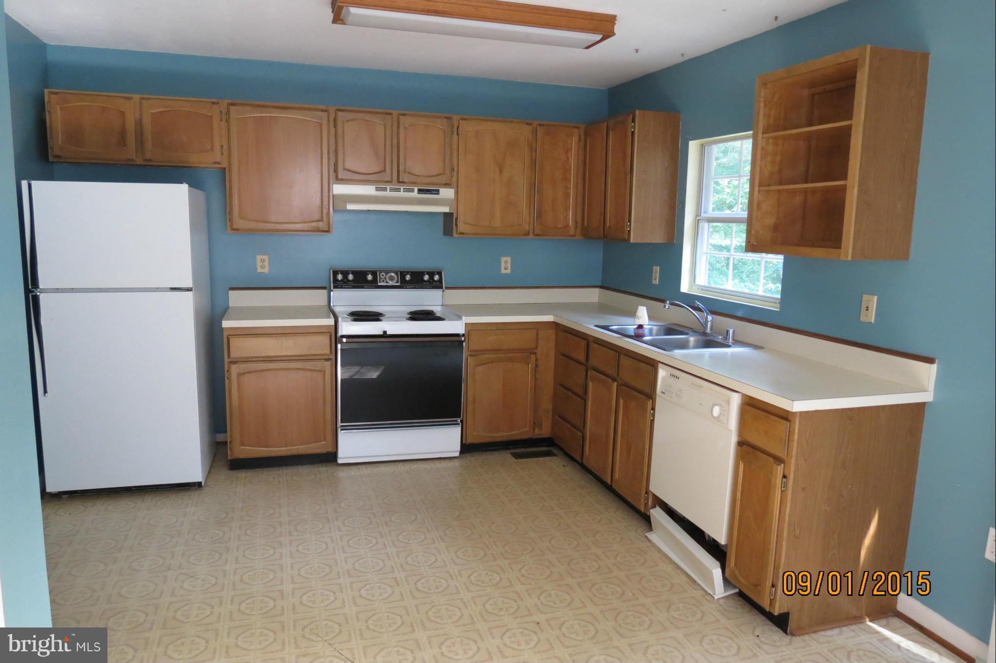 6056 Locust Road St. Leonard, MD 20685 - Photo 4 of 10 a kitchen with stainless steel appliances granite countertop a refrigerator sink and cabinets