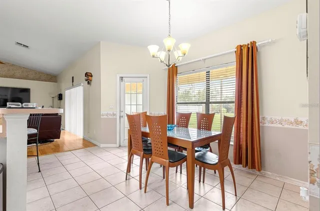 a view of a dining room with furniture and chandelier