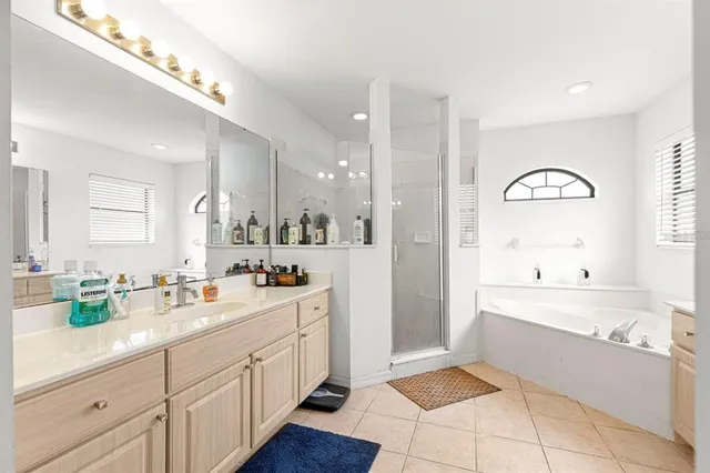 a large bathroom with a double vanity sink a mirror and a bathtub