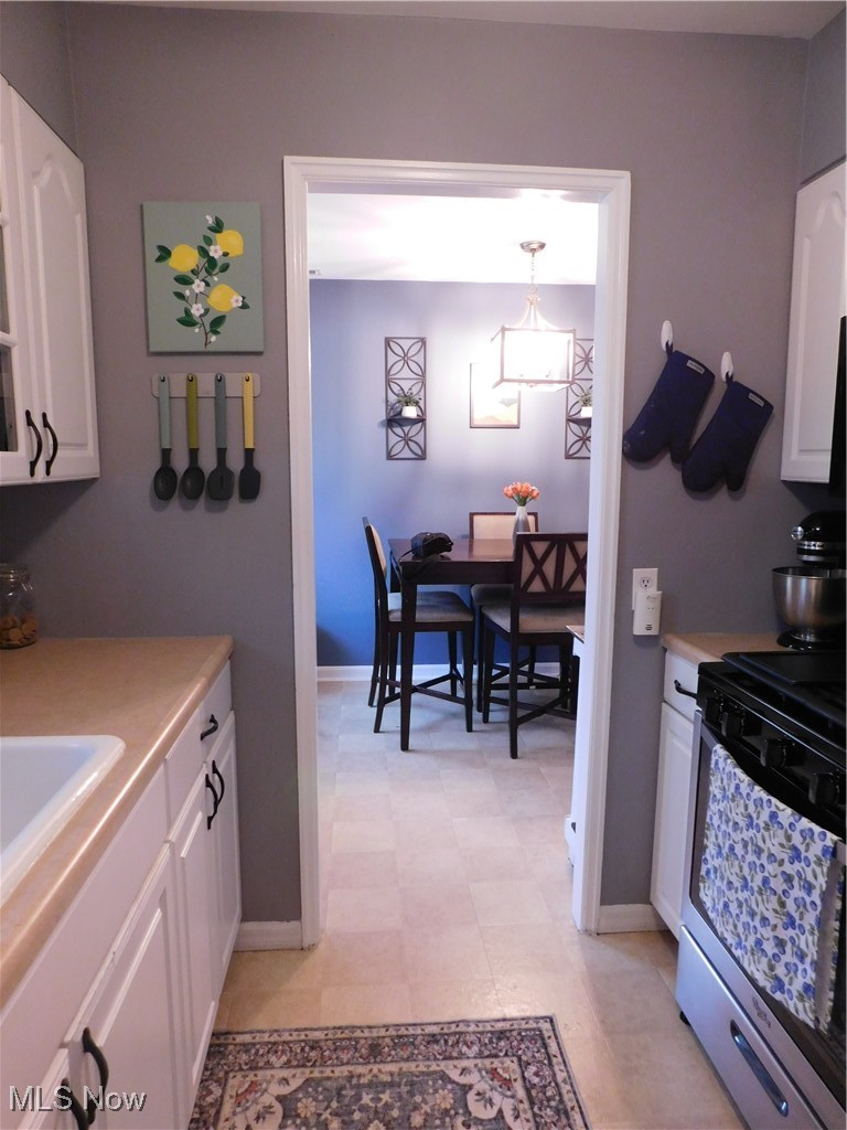 9720 West Ridgewood Drive Parma Heights, OH 44130 - Photo 12 of 46 Kitchen featuring stove, white cabinets, and light floors