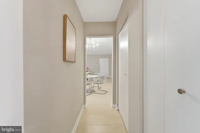 a view of a hallway with wooden floor and a bathroom