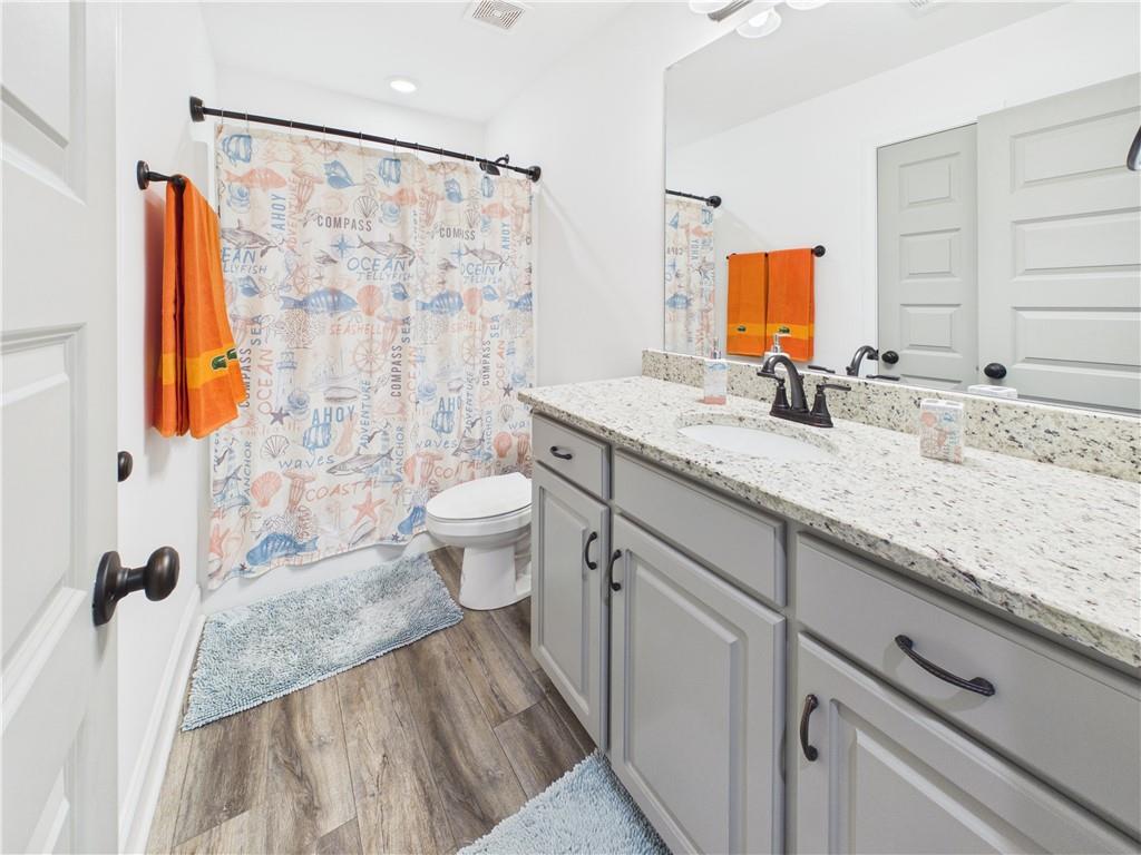 52 Owens Road Fort Mitchell, AL 36856 - Photo 22 of 29 Bathroom featuring a single vanity with light grey cabinetry, stone-finish countertop, and an undermount sink