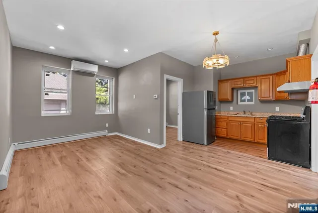 a view of a kitchen with a sink and dishwasher a refrigerator with wooden floor