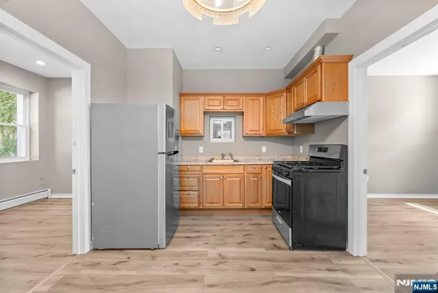 a kitchen with a refrigerator and a stove top oven