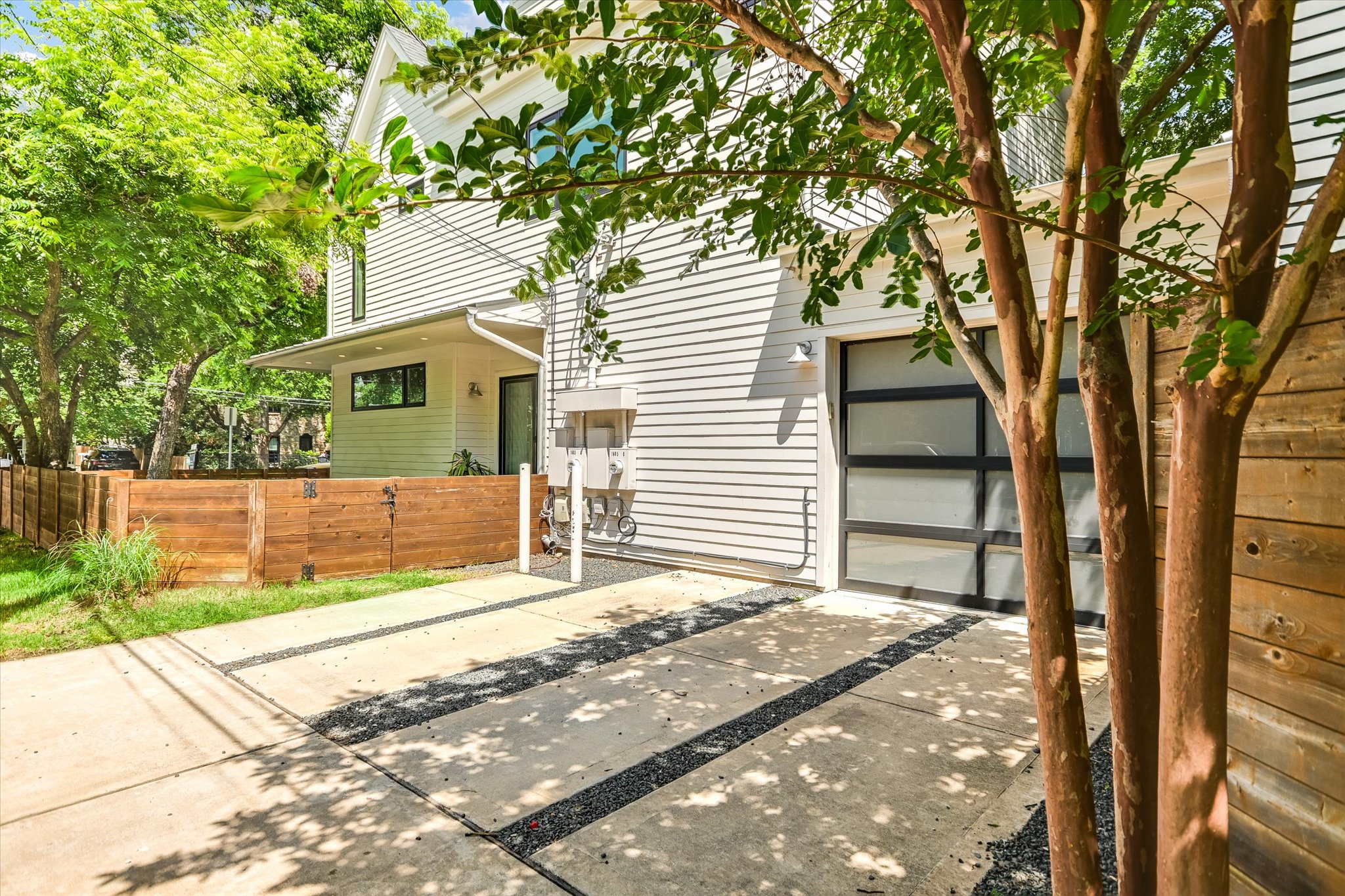 1605 Hether Street Austin, TX 78704 - Photo 26 of 26 Modern architectural design featuring white horizontal siding and a contemporary glass-paneled garage door