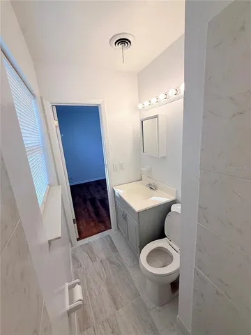 a bathroom with a toilet a sink and mirror