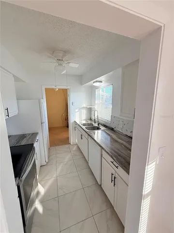 a large kitchen with a stove a sink and a refrigerator