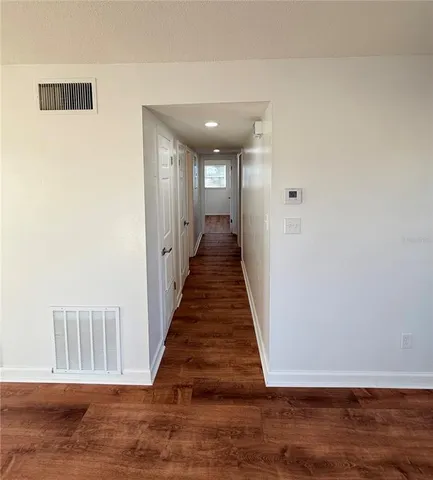 a view of a hallway with wooden floor and staircase