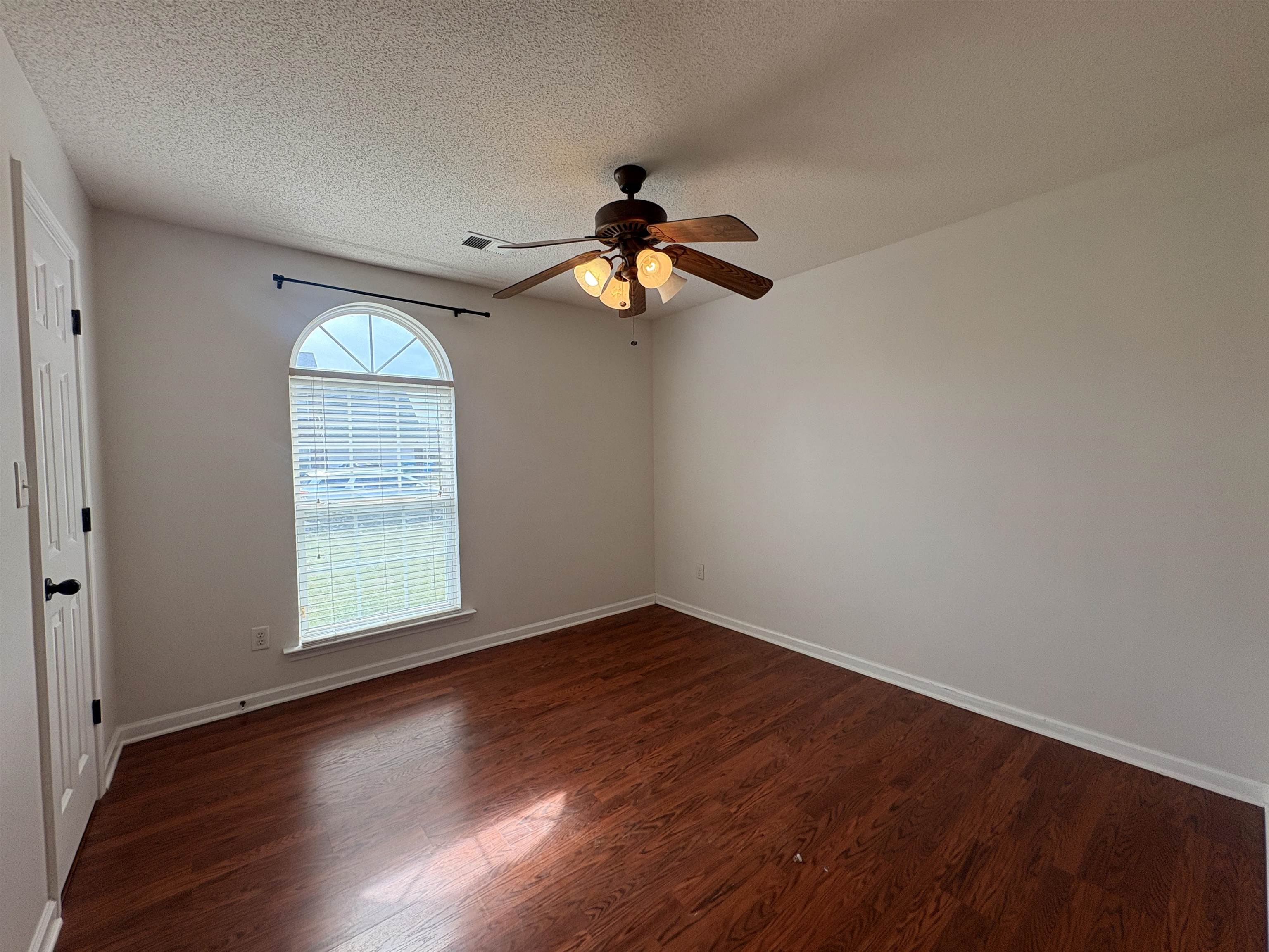 11590 Milton Ridge Cove Arlington, TN 38002 - Photo 11 of 24 Empty room featuring dark wood-style floors, a ceiling fan, and a textured ceiling
