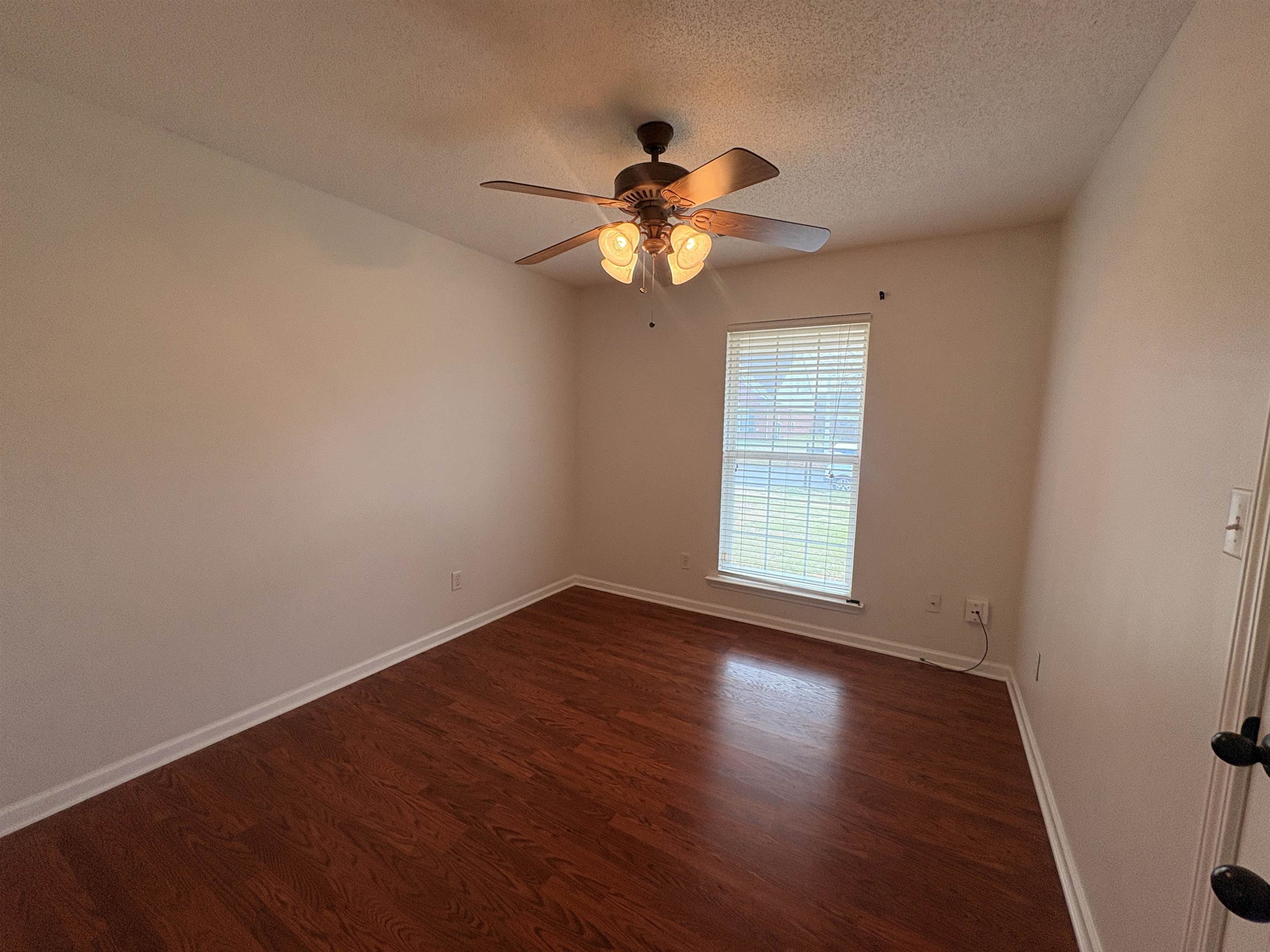 11590 Milton Ridge Cove Arlington, TN 38002 - Photo 14 of 24 Unfurnished room featuring a textured ceiling, dark wood-type flooring, and a ceiling fan