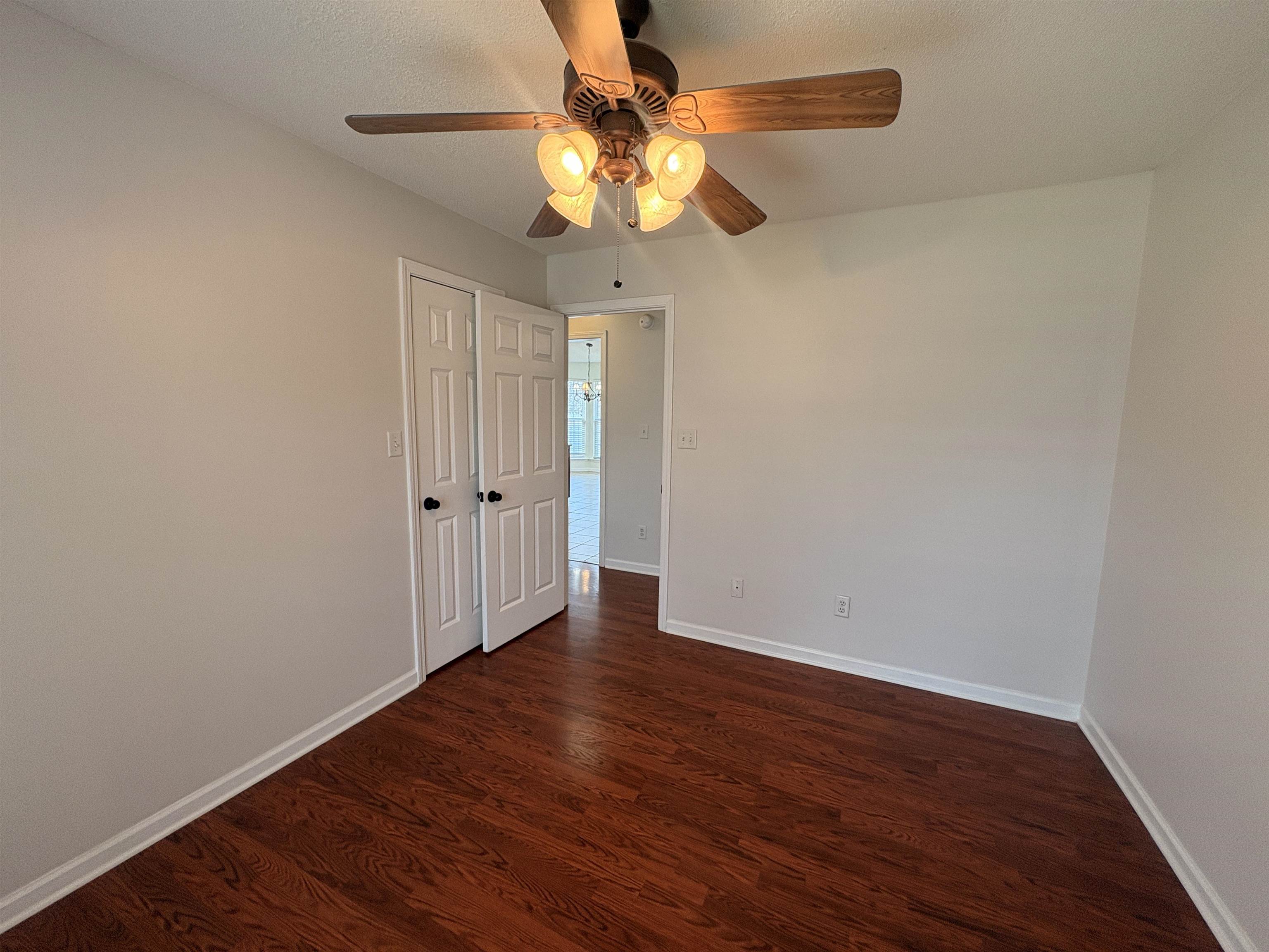 11590 Milton Ridge Cove Arlington, TN 38002 - Photo 15 of 24 Empty room with dark wood-style flooring and a ceiling fan