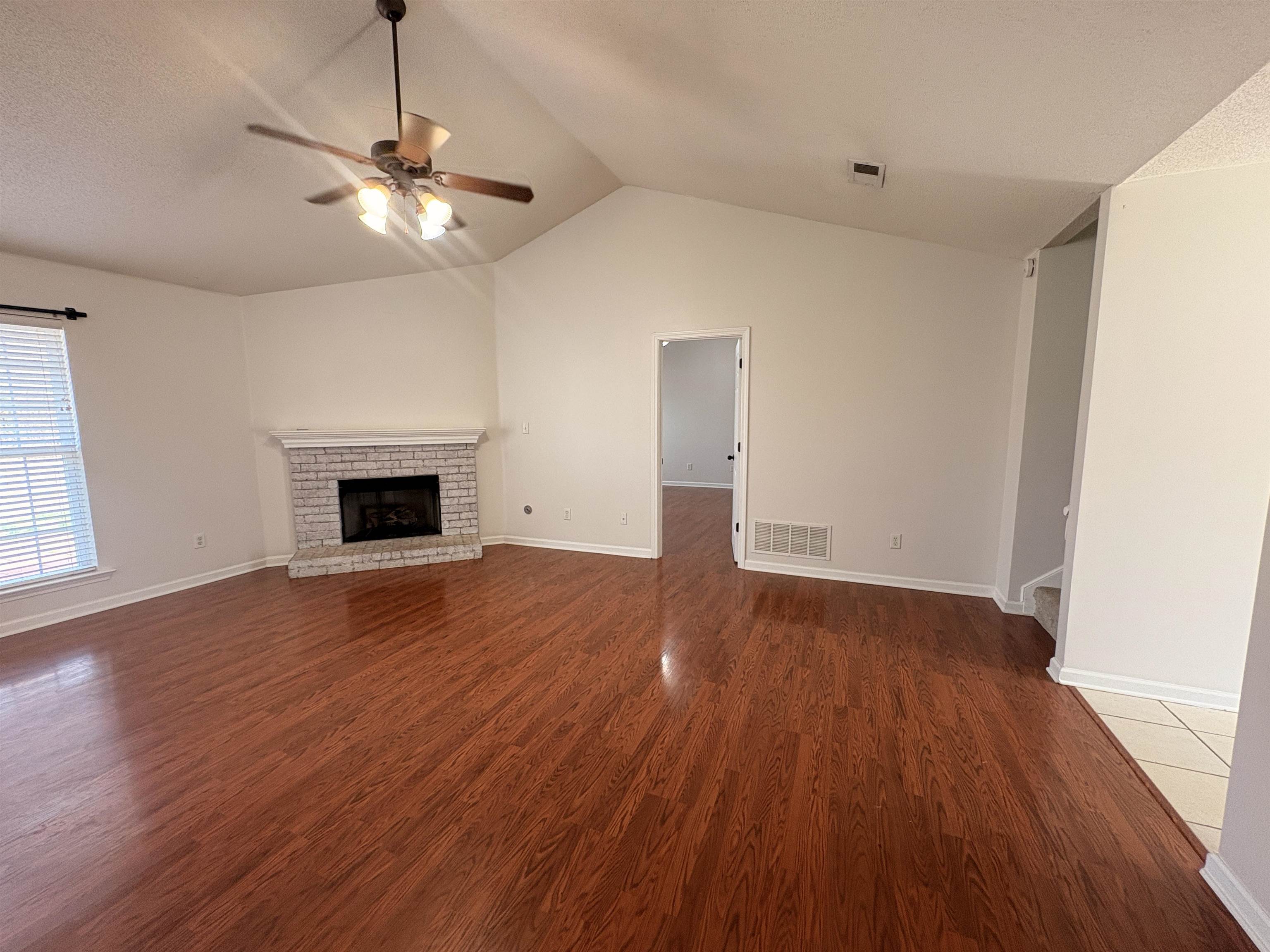11590 Milton Ridge Cove Arlington, TN 38002 - Photo 4 of 24 Unfurnished living room featuring ceiling fan, dark wood-style floors, a fireplace, and a textured ceiling