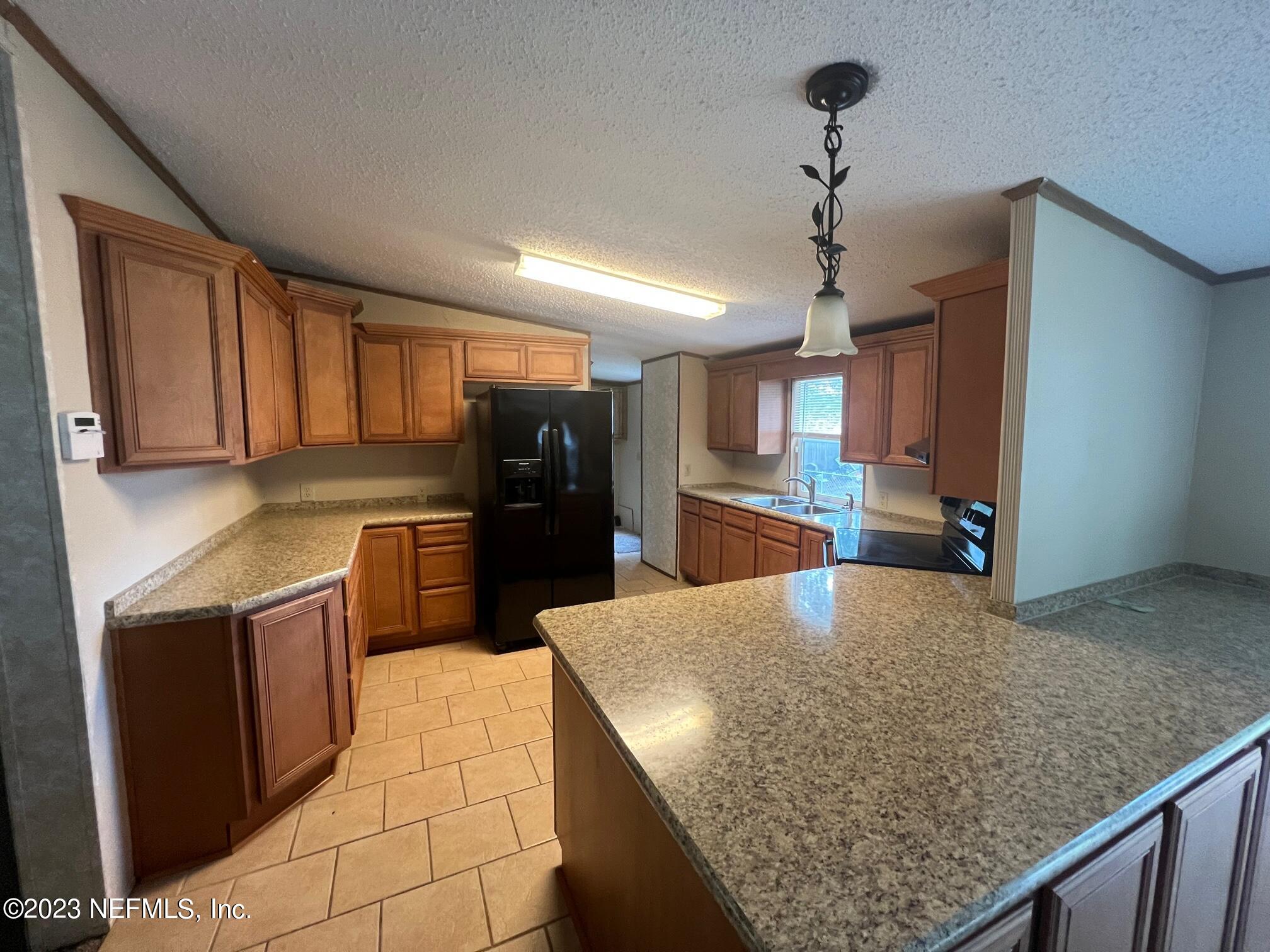 4097 South Wood Road Jacksonville, FL 32234 - Photo 5 of 7 a kitchen with stainless steel appliances granite countertop a sink stove and refrigerator