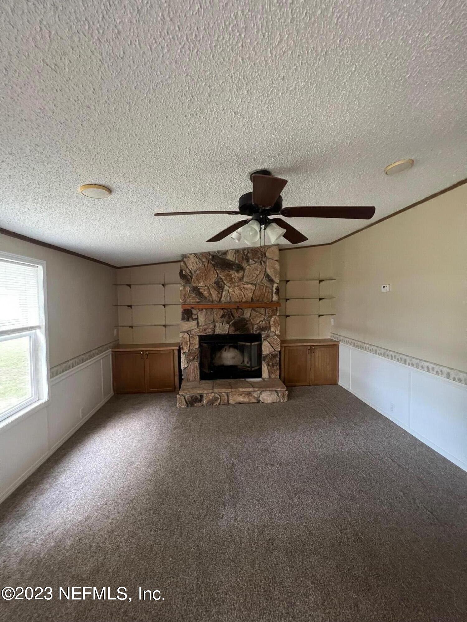 4097 South Wood Road Jacksonville, FL 32234 - Photo 6 of 7 a view of an empty room with a fireplace and window