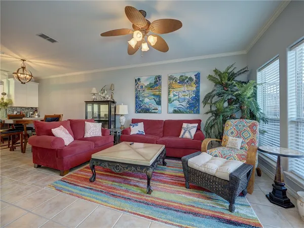 a living room with furniture chandelier and a flat screen tv