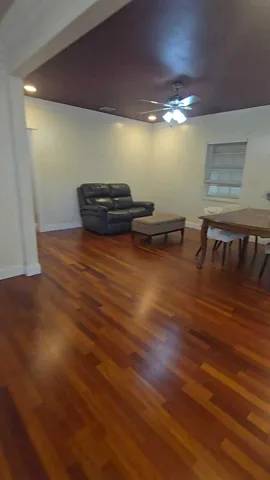 a view of a room with wooden floor and furniture