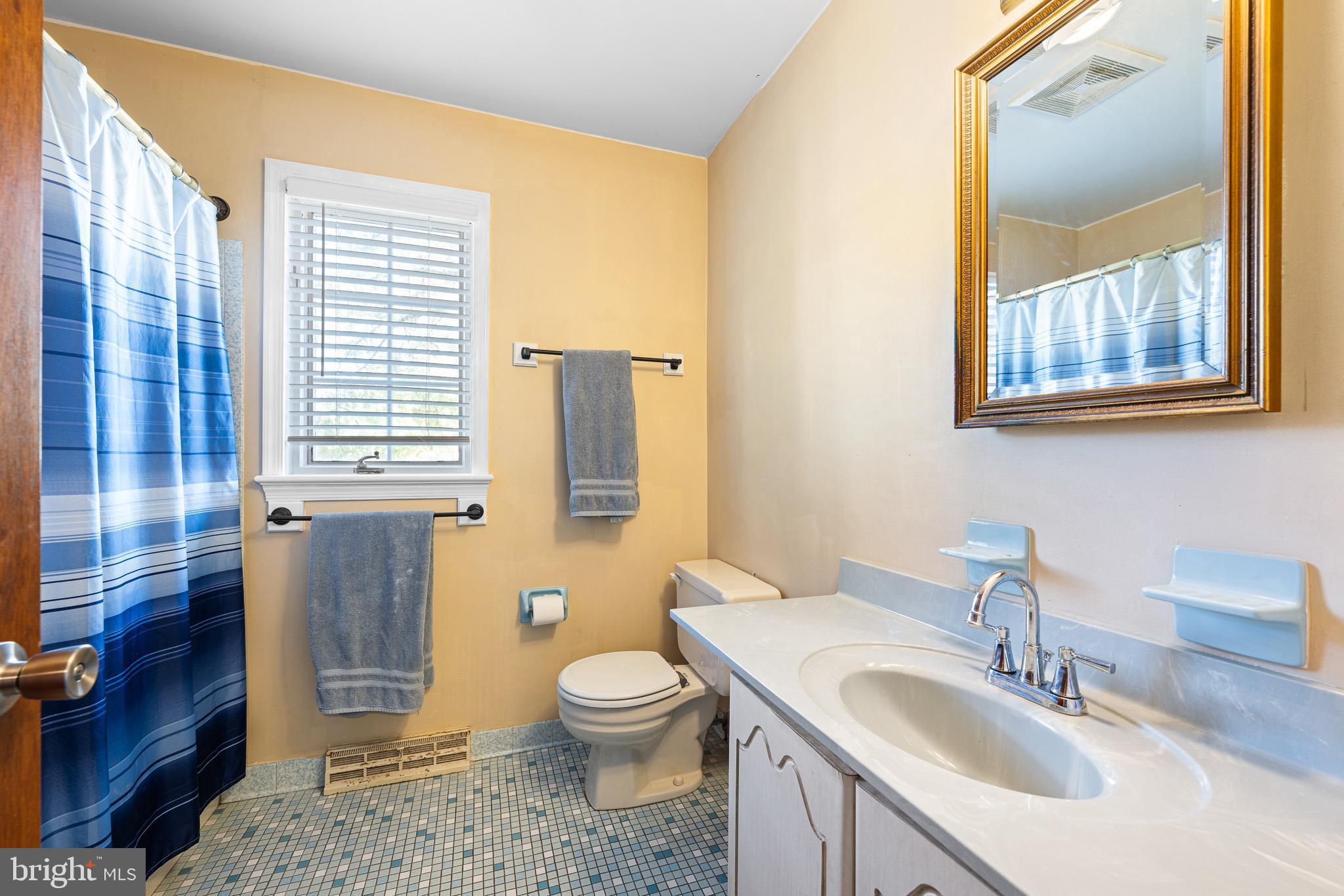 2209 Wheatleys Pond Road Smyrna, DE 19977 - Photo 18 of 39 a bathroom with a sink a toilet and a window