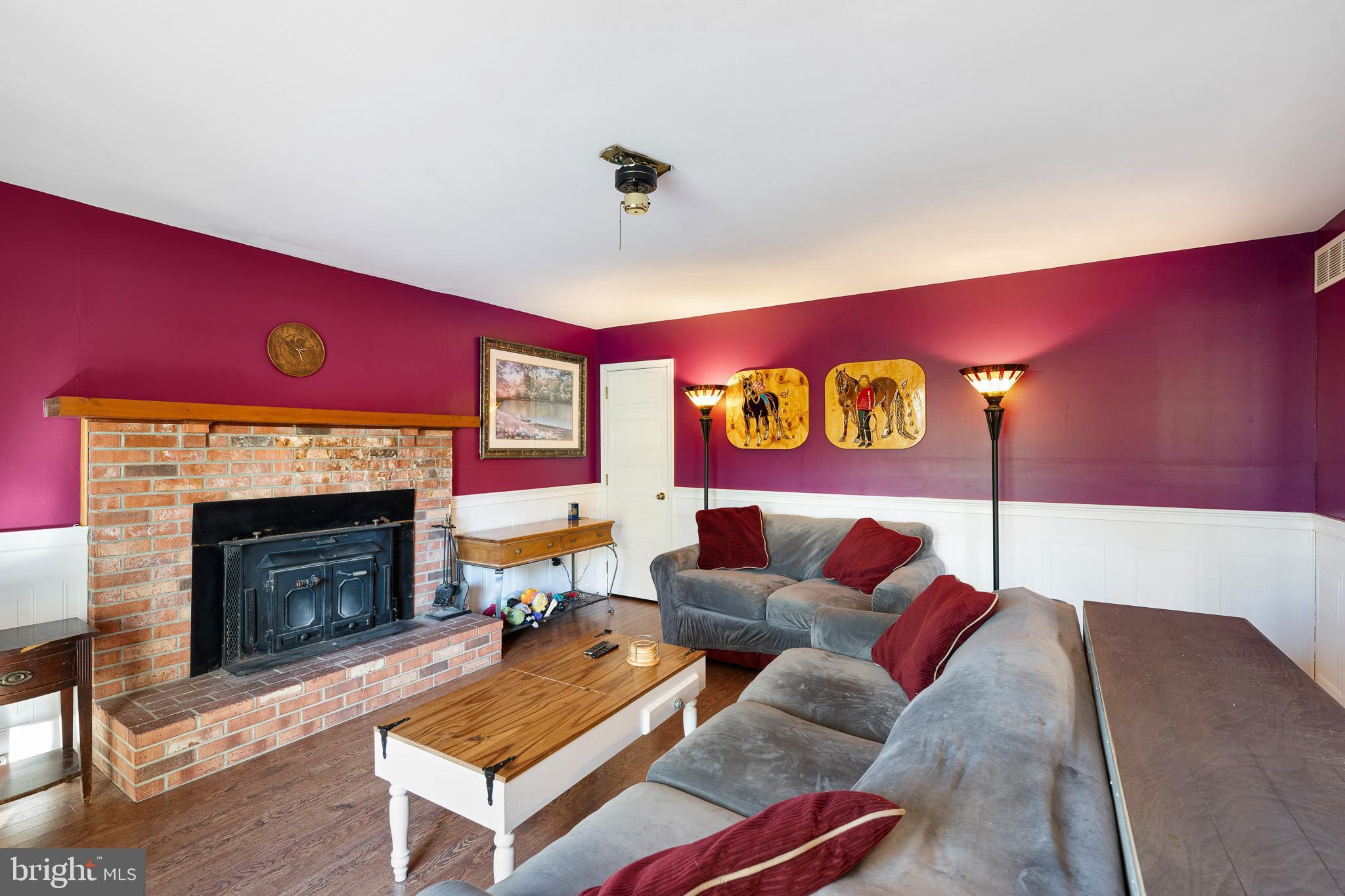 2209 Wheatleys Pond Road Smyrna, DE 19977 - Photo 5 of 39 a living room with furniture a fireplace and a flat screen tv