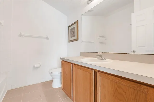 a bathroom with a granite countertop sink a toilet and a mirror