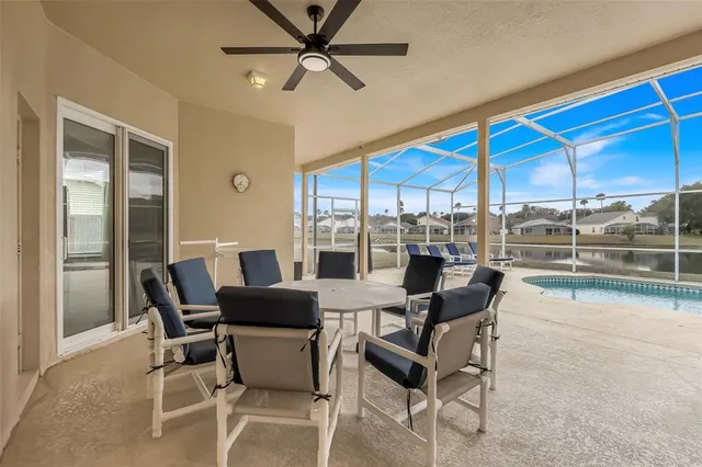 a dining room with furniture a ceiling fan and a large window