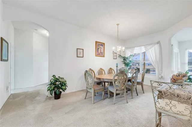 a view of a dining room with furniture and chandelier