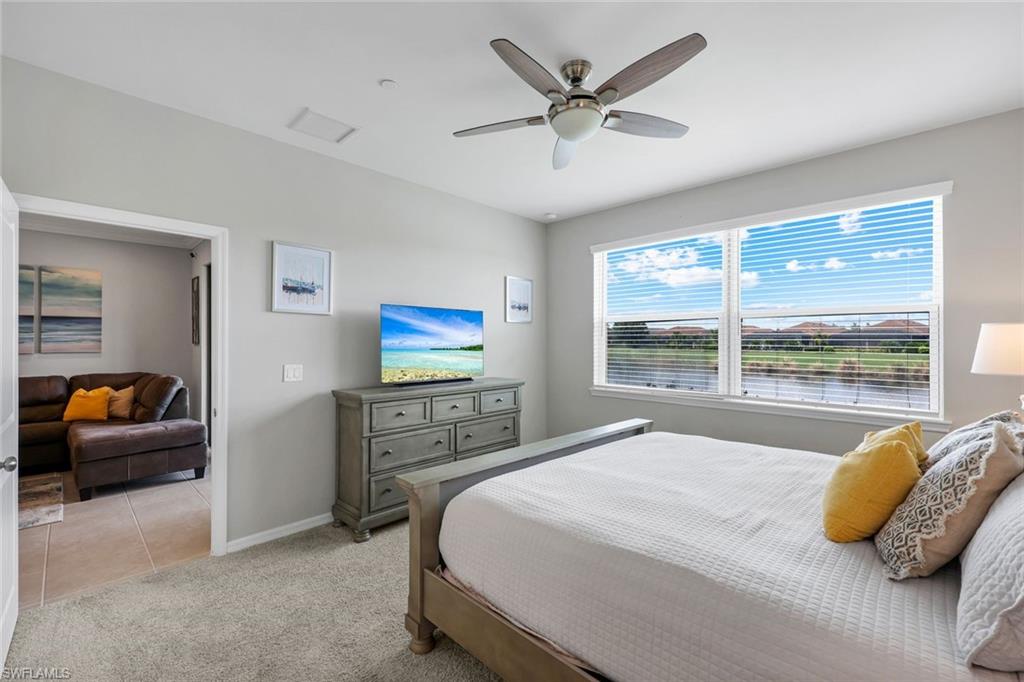 9393 Pocida Court, Unit 104 Naples, FL 34119 - Photo 11 of 28 a bedroom with a large bed and a large window