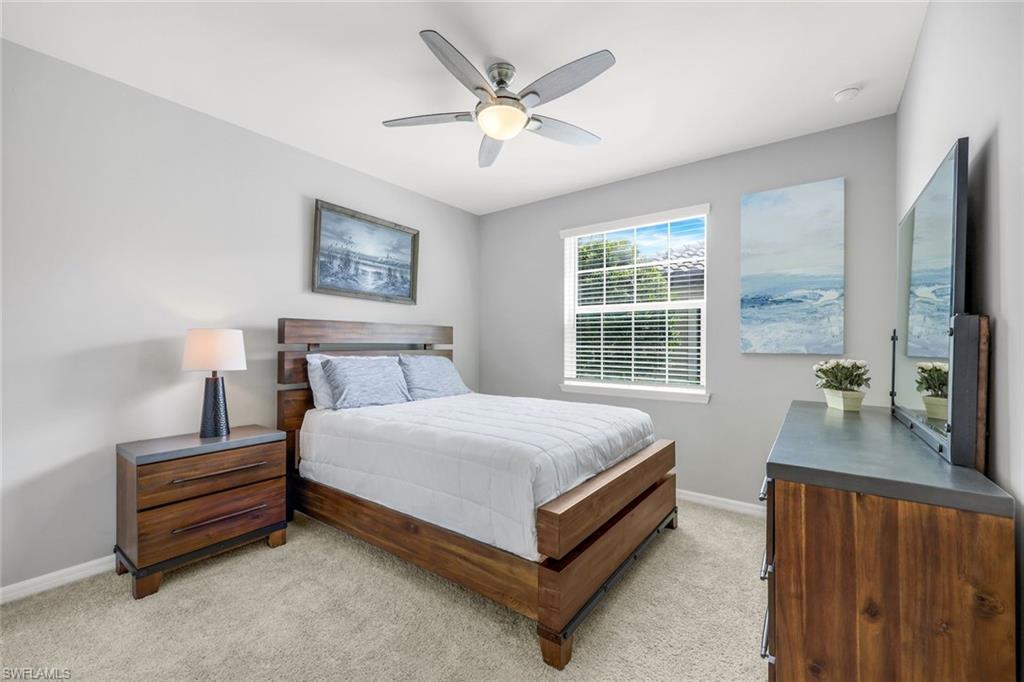 9393 Pocida Court, Unit 104 Naples, FL 34119 - Photo 15 of 28 a bedroom with a bed and a flat screen tv