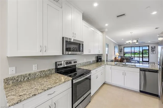 a kitchen with stainless steel appliances granite countertop a sink a stove and cabinets