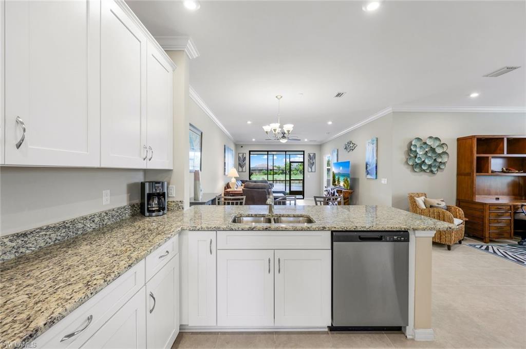 9393 Pocida Court, Unit 104 Naples, FL 34119 - Photo 6 of 28 a kitchen with stainless steel appliances granite countertop a sink stove and cabinets