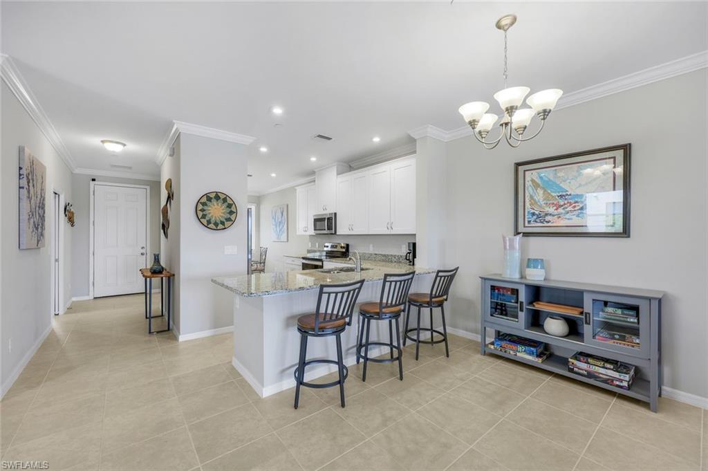 9393 Pocida Court, Unit 104 Naples, FL 34119 - Photo 7 of 28 a view of a dining room with furniture