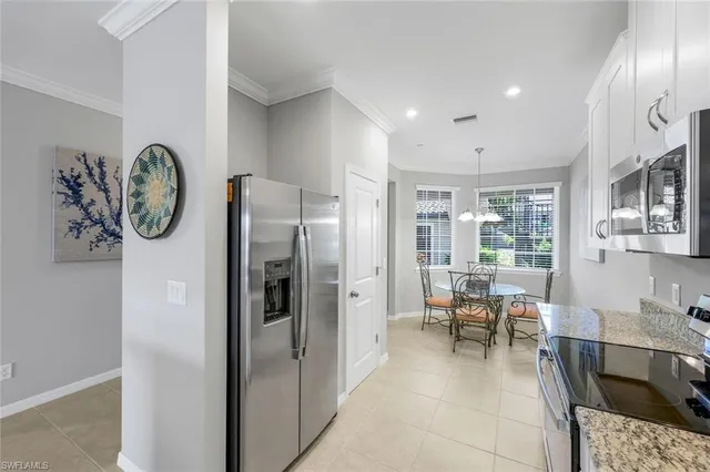 a living room with furniture a large window and stainless steel appliances
