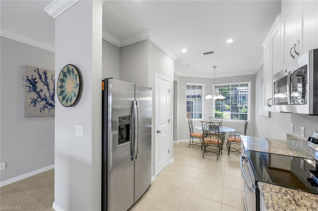 9393 Pocida Court, Unit 104 Naples, FL 34119 - Photo 8 of 28 a living room with furniture a large window and stainless steel appliances