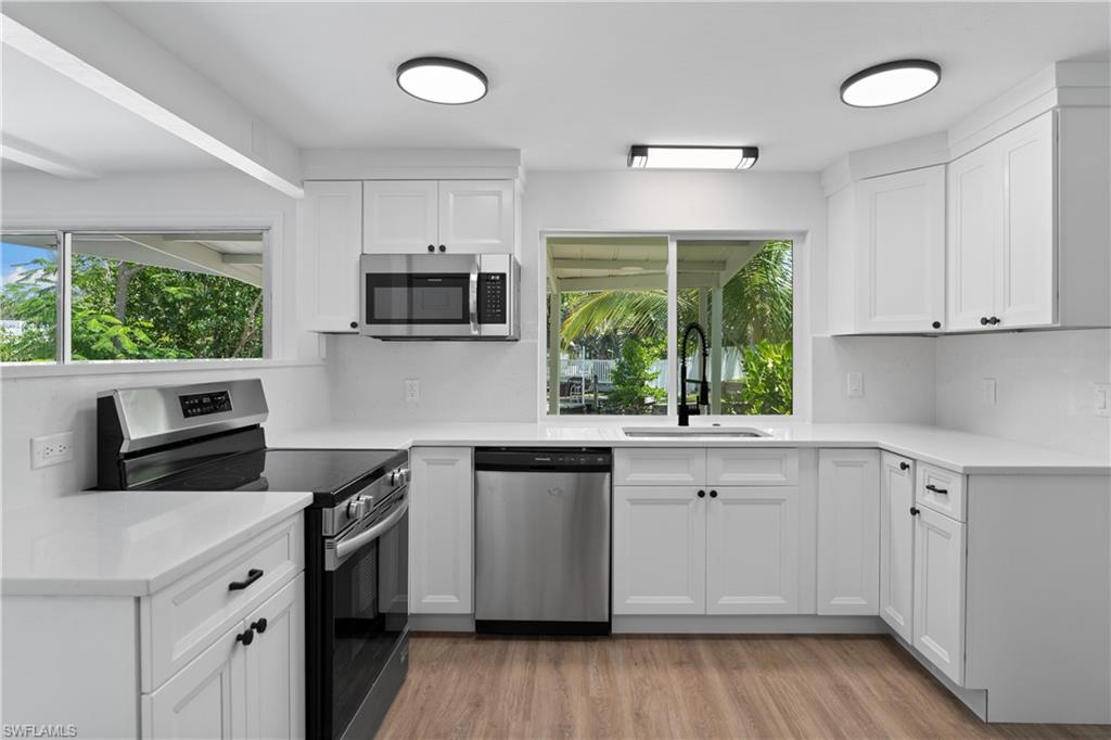 66 River Court Naples, FL 34110 - Photo 12 of 29 a kitchen with a stove a sink and a microwave