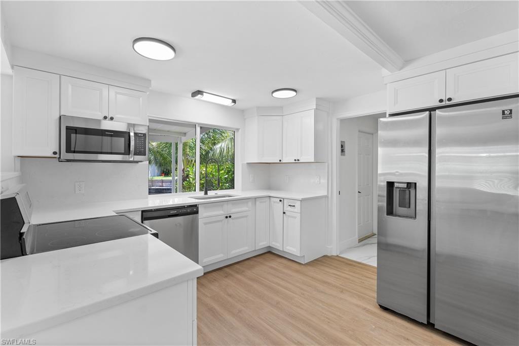 66 River Court Naples, FL 34110 - Photo 13 of 29 a kitchen with stainless steel appliances a refrigerator sink and microwave