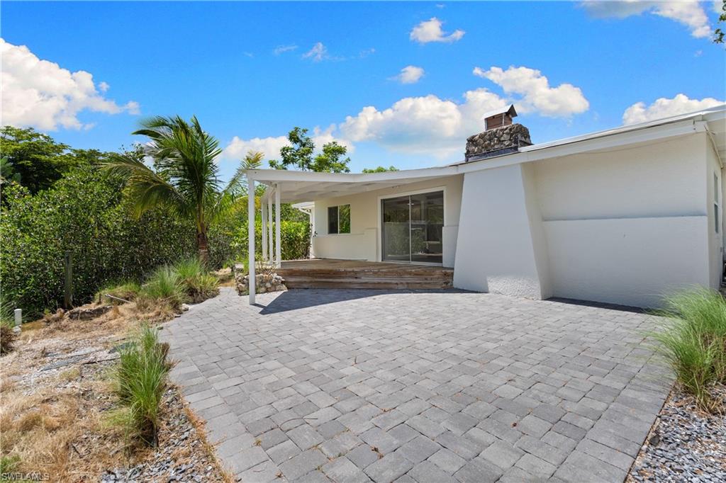 66 River Court Naples, FL 34110 - Photo 18 of 29 a view of a house with a yard and potted plants