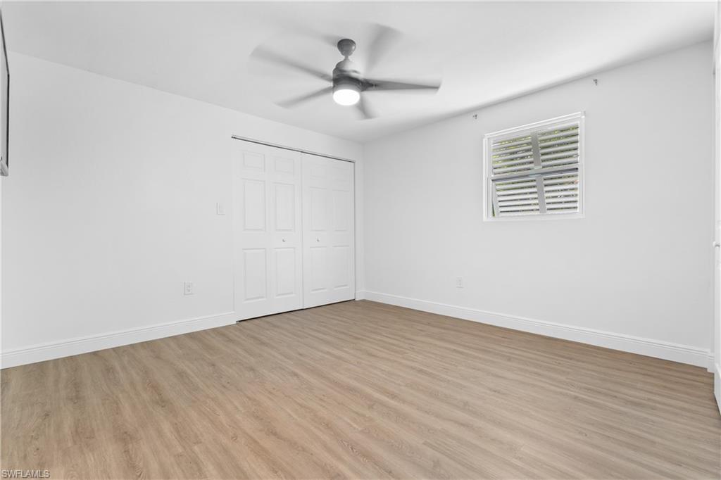66 River Court Naples, FL 34110 - Photo 20 of 29 wooden floor in an empty room with a window